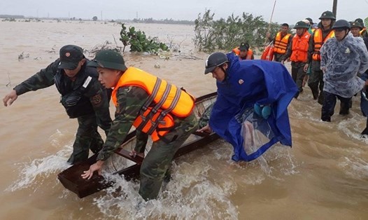 Lực lượng chức năng hỗ trợ người dân ứng phó với mưa lũ. Ảnh: TL