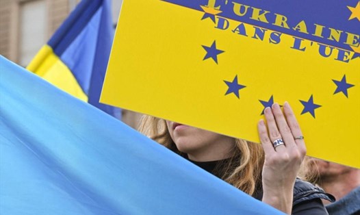 Một người cầm biểu ngữ ủng hộ Ukraina gia nhập EU ở Pháp, tháng 3.2022. Ảnh: AFP