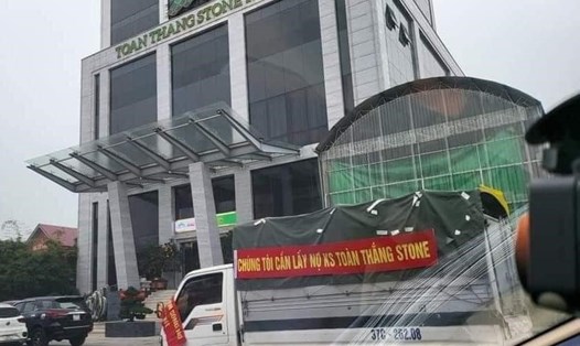 Xe tải có băng rôn đòi nợ chủ đầu tư khách sạn Toàn Thắng đi qua trước cổng khách sạn. Ảnh: PL