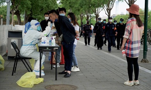 Nhân viên y tế lấy mẫu xét nghiệm Covid-19 cho người dân ở Bắc Kinh, Trung Quốc, ngày 1.5. Ảnh: AFP