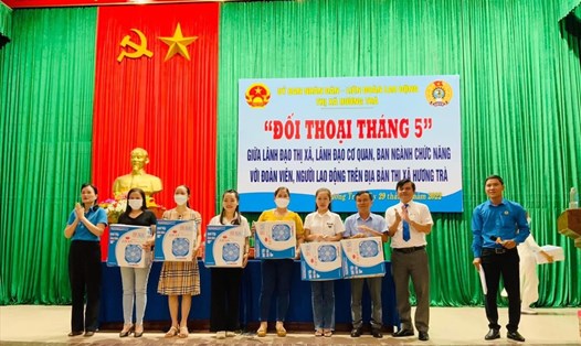 Bà Trần Thị Minh Nguyệt (áo xanh, trái) - Phó Chủ tịch LĐLĐ Thừa Thiên Huế và ông Đỗ Ngọc An - Phó Chủ tịch UBND thị xã Hương Trà trao quà cho đoàn viên, người lao động. Ảnh: CTV.
