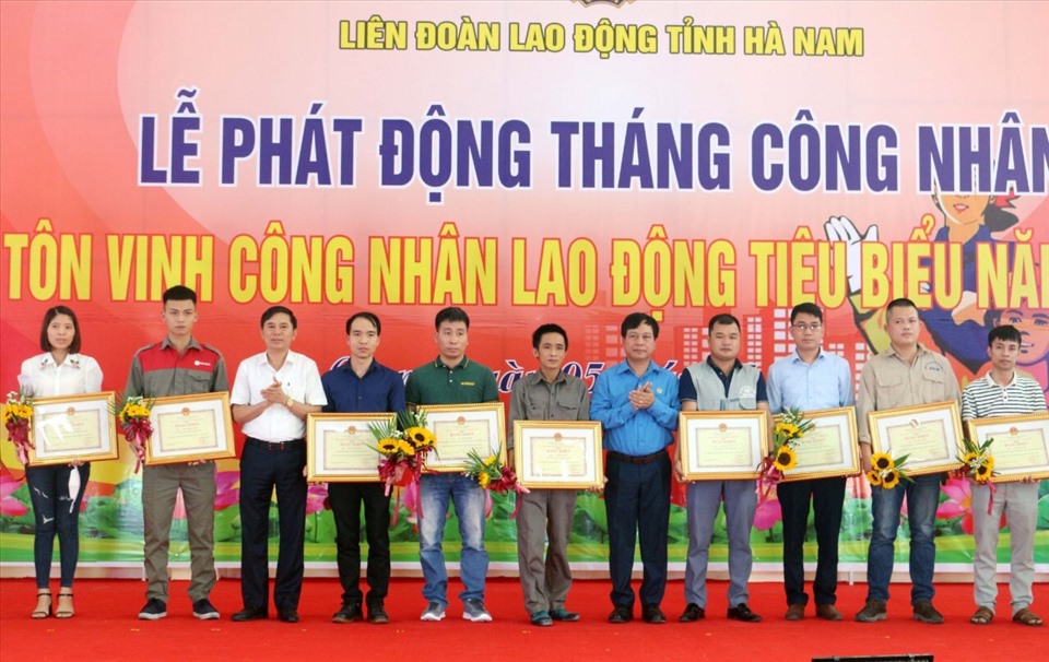 Ông Trần Xuân Dưỡng - Phó Chủ tịch Uỷ ban nhân dân tỉnh Hà Nam (thứ 3, từ trái qua) và ông Vũ Anh Đức - Ủy viên Đoàn Chủ tịch, Trưởng ban Tổ chức Tổng Liên đoàn Lao động Việt Nam (thứ 5, từ phải qua) trao Bằng khen của Uỷ ban nhân dân tỉnh cho công nhân lao động tiêu biểu năm 2021.