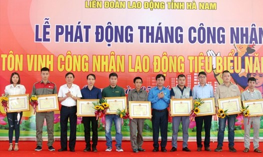 Ông Trần Xuân Dưỡng - Phó Chủ tịch Uỷ ban nhân dân tỉnh Hà Nam (thứ 3, từ trái qua) và ông Vũ Anh Đức - Ủy viên Đoàn Chủ tịch, Trưởng ban Tổ chức Tổng Liên đoàn Lao động Việt Nam (thứ 5, từ phải qua) trao Bằng khen của Uỷ ban nhân dân tỉnh cho công nhân lao động tiêu biểu năm 2021.