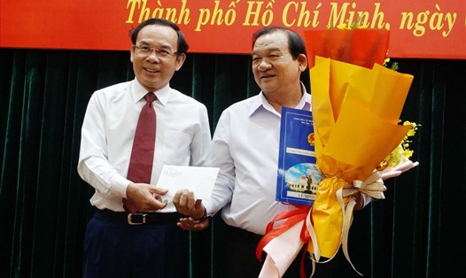 Bí thư Thành ủy TPHCM Nguyễn Văn Nên (trái) trao quyết định nghỉ hưu cho ông Lê Minh Tấn.  Ảnh: Minh Quân