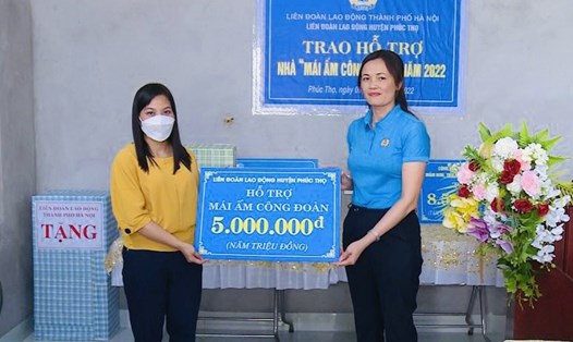 Chủ tịch Liên đoàn Lao động huyện Phúc Thọ Nguyễn Thị Lan Anh (bên phải ảnh) trao hỗ trợ cho đoàn viên Tuyết Nhung. Ảnh: CĐH
