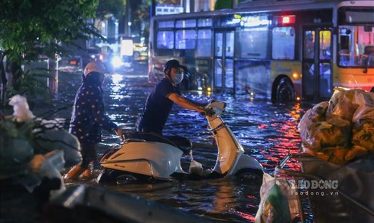 Mưa xảy ra với cường suất lớn gây ngập lụt nhiều tuyến phố ở Hà Nội đêm 13.6. Ảnh: Tô Thế.