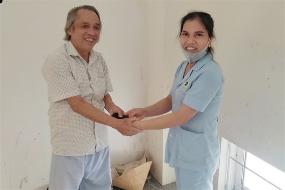 Hộ lý Hạnh trả lại ví cho bệnh nhân Đại. Ảnh: NT.