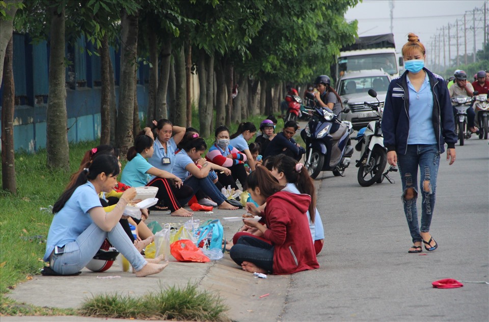 Công nhân tranh thủ ăn cơm trước giờ vào ca. Ảnh: Đ.T