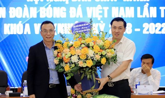 Quyền Chủ tịch VFF - Trần Quốc Tuấn (trái) - gửi lời chúc mừng và tặng hoa Phó Chủ tịch Cao Văn Chóng. Ảnh: VFF