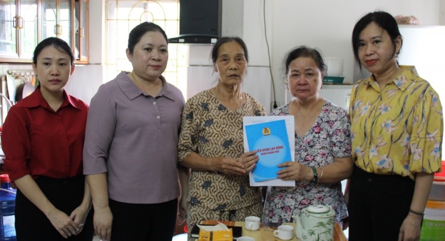 Bà Bùi Thị Ngọc Thủy - Chủ tịch Liên đoàn Lao động quận Hoàng Mai (thứ hai từ trái qua) trao hỗ trợ của Liên đoàn Lao động Thành phố và Liên đoàn Lao động quận tới người thân của đoàn viên Hà Thị Như Quỳnh. Ảnh: CĐQ