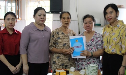 Bà Bùi Thị Ngọc Thủy - Chủ tịch Liên đoàn Lao động quận Hoàng Mai (thứ hai từ trái qua) trao hỗ trợ của Liên đoàn Lao động Thành phố và Liên đoàn Lao động quận tới người thân của đoàn viên Hà Thị Như Quỳnh. Ảnh: CĐQ