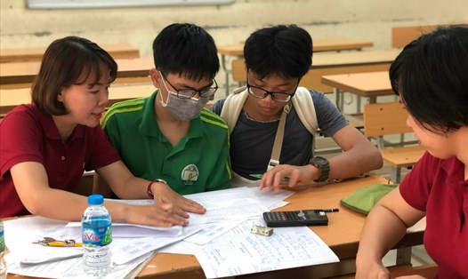 Học sinh lớp 8 hỗ trợ "đàn anh" viết bài thi kỳ thi tuyển sinh lớp 10 năm học 2022. Ảnh: NVCC