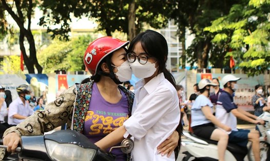 Chị Nguyễn Hương Quỳnh đưa con đến điểm thi Trường THCS Khương Hạ từ sớm. Trước khi con vào phòng thi, chị không quên trao nụ hôn để tiếp thêm động lực. Ảnh: Minh Hà