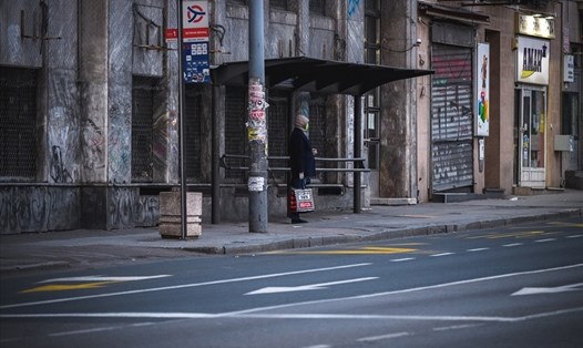 Một cư dân ở Belgrade, Serbia đợi xe buýt vào ngày 30.3.2020. Ảnh minh họa. Ảnh: AFP