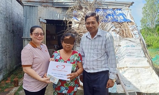 Phó Giám đốc Sở Lao động Thương binh và Xã hội tỉnh Bạc Liêu hỗ trợ 30 triệu đồng cho bà V. Ảnh: Nhật Hồ