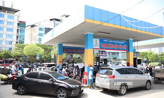 Người dân Hà Nội "đội nắng" đi đổ xăng trước giờ tăng giá.
