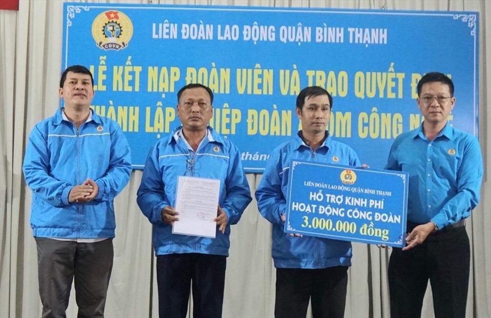 Ông Cao Hoàng Hà - bên phải - Chủ tịch LĐLĐ quận trao hỗ trợ kinh phí ban đầu cho Ban chấp hành nghiệp đoàn. Ảnh: Đức Long