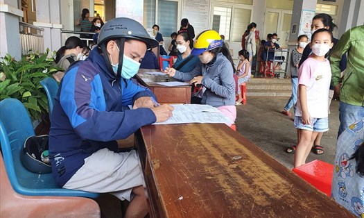 Người dân đến làm thủ tục tiêm vaccine COVID-19 mũi thứ 2 cho con tại Trạm y tế phường Tân An (TP.Buôn Ma Thuột, tỉnh Đắk Lắk). Ảnh: Bảo Trung
