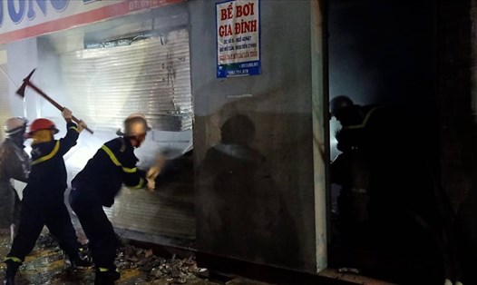 Cảnh sát PCCC phá cửa cuốn cứu người dân tại đám cháy. Ảnh: CACC