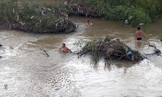Người dân và lực lượng chức năng tìm kiếm thi thể cháu bé bị đuối nước. Ảnh: CTV