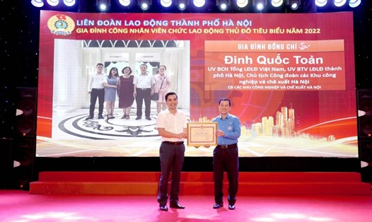 Anh Đinh Quốc Toản - Chủ tịch CĐ các KCN-CX Hà Nội (bên phải) nhận danh hiệu Gia đình CNVCLĐ tiêu biểu Thủ đô năm 2022. Ảnh: MQ