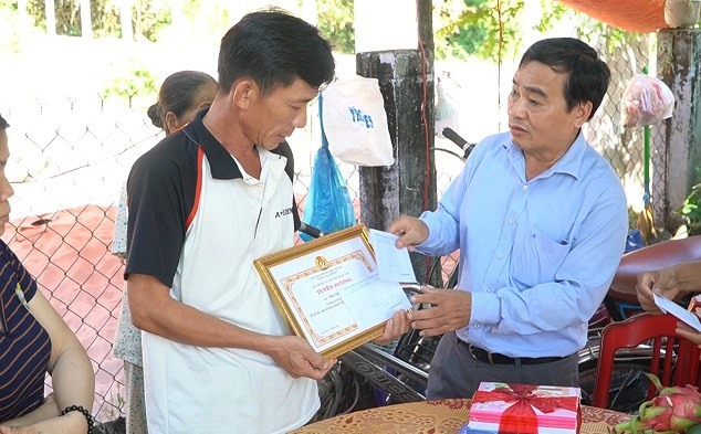 Ông Phan Xuân Quang – Chủ tịch LĐLĐ tỉnh Quảng Nam trao cho gia đình em Văn Đức Hội phần quà khen thưởng cho học sinh là con CNLĐ vượt khó học giỏi
năm học 2021-2022. Ảnh: Đại Quang