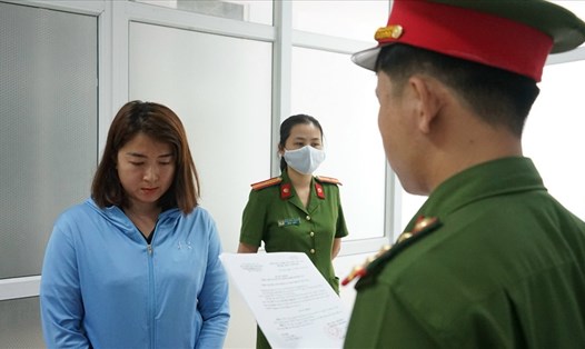 Lực lượng chức năng tống đạt quyết định khởi tố, bắt tạm giam Lê Thị Thảo Nguyên. Ảnh: Công an