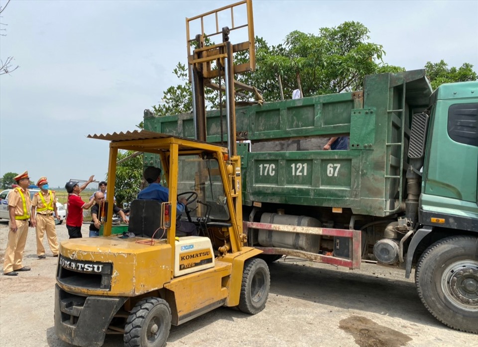 Công ty TNHH Xây dựng Quang Tuấn thực hiện hạ tải phương tiện trước sự giám sát của lực lượng CSGT - Công an tỉnh Thái Bình. Ảnh: T.D