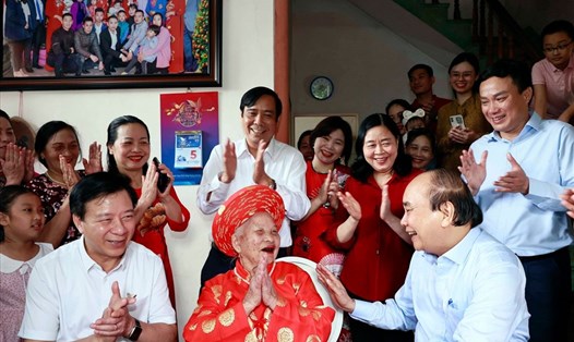 Chủ tịch nước Nguyễn Xuân Phúc thăm và tặng quà cho cụ Phạm Thị Lứu. Ảnh: TTXVN.