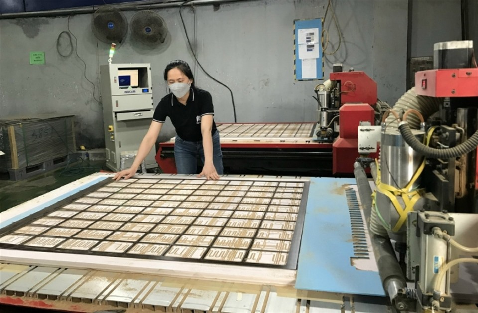 Chị Lê Thị Ánh Tuyết với sáng kiến cải tiến máy cắt miếng điệm Bakelit, một người đứng 2 máy. Ảnh: Phạm Đông