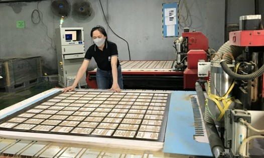 Chị Lê Thị Ánh Tuyết với sáng kiến cải tiến máy cắt miếng điệm Bakelit, một người đứng 2 máy. Ảnh: Phạm Đông