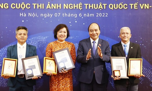 Chủ tịch nước Nguyễn Xuân Phúc trao Huy chương Vàng, bằng chứng nhận cho các tác giả xuất sắc đoạt giải cao. Ảnh: TTXVN