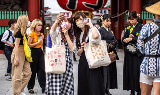 Khách du lịch nước ngoài đến Nhật Bản vẫn phải đeo khẩu trang. Ảnh: AFP