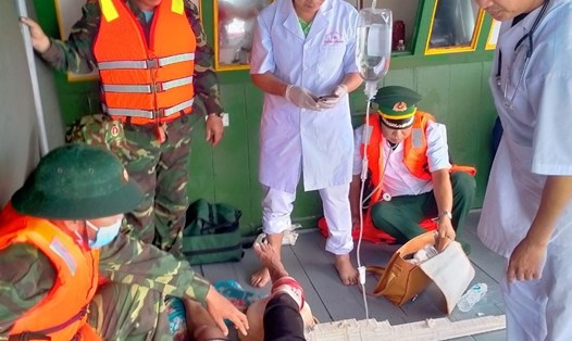 Lực lượng Biên phòng và y bác sỹ Trung tâm y tế Bạch Long Vỹ cấp cứu nạn nhân bị cá mập tấn công. Ảnh: Sơn Hà