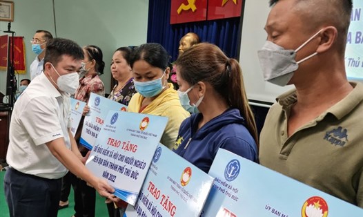 Ông Phan Bửu Đảo - Phó Chủ tịch Công đoàn Cơ quan Tổng Công ty phát điện 3 - trao tặng biều trưng sổ BHXH cho các hộ dân nghèo. Ảnh: Nam Dương