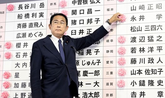 Thủ tướng Fumio Kishida gắn hoa lên tên những người thắng cử của đảng LDP trong cuộc bầu cử thượng viện ngày 10.7.2022. Ảnh: Kyodo
