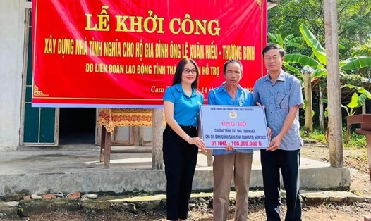 Đại diện lãnh đạo LĐLĐ tỉnh Quảng Trị trao khoản tiền 100 triệu đồng của LĐLĐ tỉnh Thái Nguyên cho gia đình ông Hiếu. Ảnh: CĐTN
