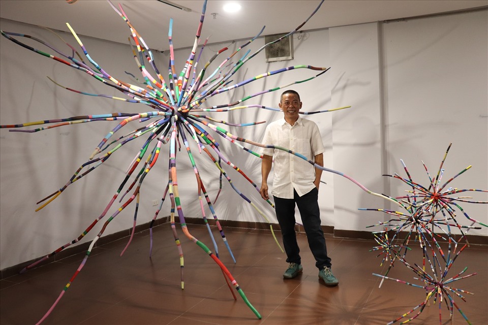 Nhà điêu khắc Đàm Đăng Lại và tác phẩm của mình trong triển lãm "Điêu khắc Đàm Đăng Lại" được tổ chức tại Bảo tàng Mỹ thuật Đà Nẵng. Ảnh: Nguyễn Linh