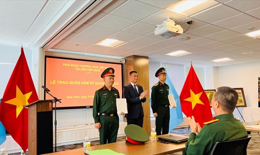 Đại sứ Đặng Hoàng Giang (giữa) trao quân hàm cho Thượng tá Lương Trường Vinh (trái) và Trung tá Nguyễn Phúc Đông (phải). Ảnh: Thùy Linh