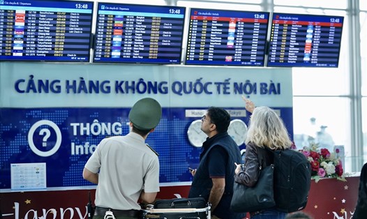 Một nhân viên an ninh hỗ trợ hướng dẫn hành khách tại sân bay Nội Bài. Ảnh NIA