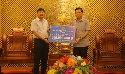 Ông Phan Văn Anh (trái ảnh) - Phó Chủ tịch Tổng LĐLĐ Việt Nam trao tiền hỗ trợ xây dựng nhà tình nghĩa. Ảnh: Hưng Thơ.