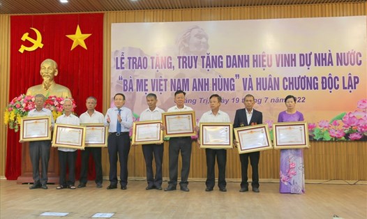 Ông Võ Sỹ Điền (thứ 2 từ phải sang) nhận danh hiệu Bà mẹ Việt Nam Anh hùng của bà Lê Thị Con. Ảnh: Hưng Thơ.