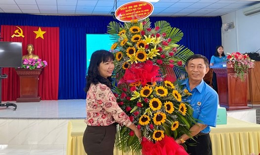 Đồng chí Thi Hồng Thúy - Phó Bí thư Thường trực Huyện ủy Phú Tân - tặng hoa chúc mừng 93 năm Ngày thành lập Công đoàn Việt Nam.