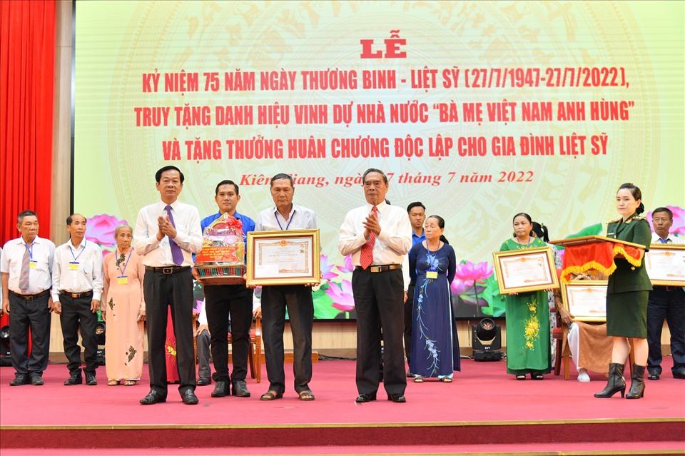 Nguyên Ủy viên Bộ Chính trị, nguyên Thường trực Ban Bí thư Trung ương Đảng Lê Hồng Anh (bìa phải) và Ủy viên Trung ương Đảng, Bí thư Tỉnh ủy Kiên Giang Đỗ Thanh Bình (bìa trái) trao danh hiệu vinh dự Nhà nước “Bà mẹ Việt Nam anh hùng” cho thân nhân các mẹ Việt Nam anh hùng. Ảnh: PV