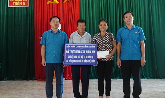 Liên đoàn lao động Hà Tĩnh trao hỗ trợ kinh phí cho thôn 5 xã Điền Mỹ xây dựng nông thôn mới. Ảnh: Trần Tuấn.