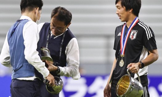 Các thành viên của tuyển Nhật Bản bối rối khi chiếc cúp vô địch Đông Á bị bung ra. Ảnh: Nikkan Sports