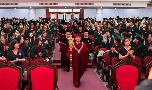 Hiệu trưởng Trường Đại học Kinh tế, Đại học Quốc gia Hà Nội cầm cây quyền trượng, khoác áo thụng, đeo vòng cổ cùng đoàn giảng viên bước vào buổi lễ