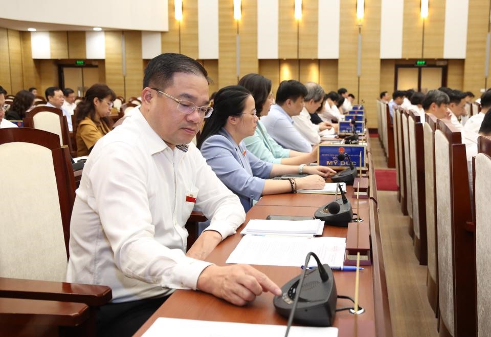 Các đại biểu tham dự Kỳ họp bấm nút thông qua Nghị quyết. Ảnh: TTBC