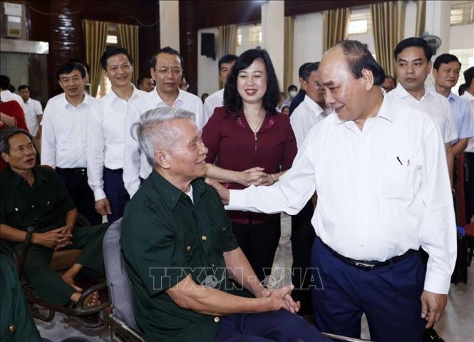 Chủ tịch nước Nguyễn Xuân Phúc tới thăm, tặng quà các bộ, nhân viên và thương binh Trung tâm Điều dưỡng Thương binh Thuận Thành. Ảnh: TTXVN.