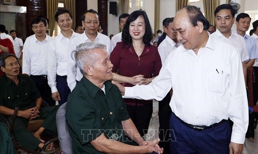 Chủ tịch nước Nguyễn Xuân Phúc tới thăm, tặng quà các bộ, nhân viên và thương binh Trung tâm Điều dưỡng Thương binh Thuận Thành. Ảnh: TTXVN.